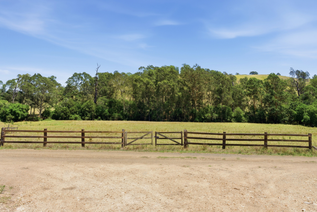 Timber paddock gates and fence line with bush and hills at Strathbrook Farm, Dungog NSW
