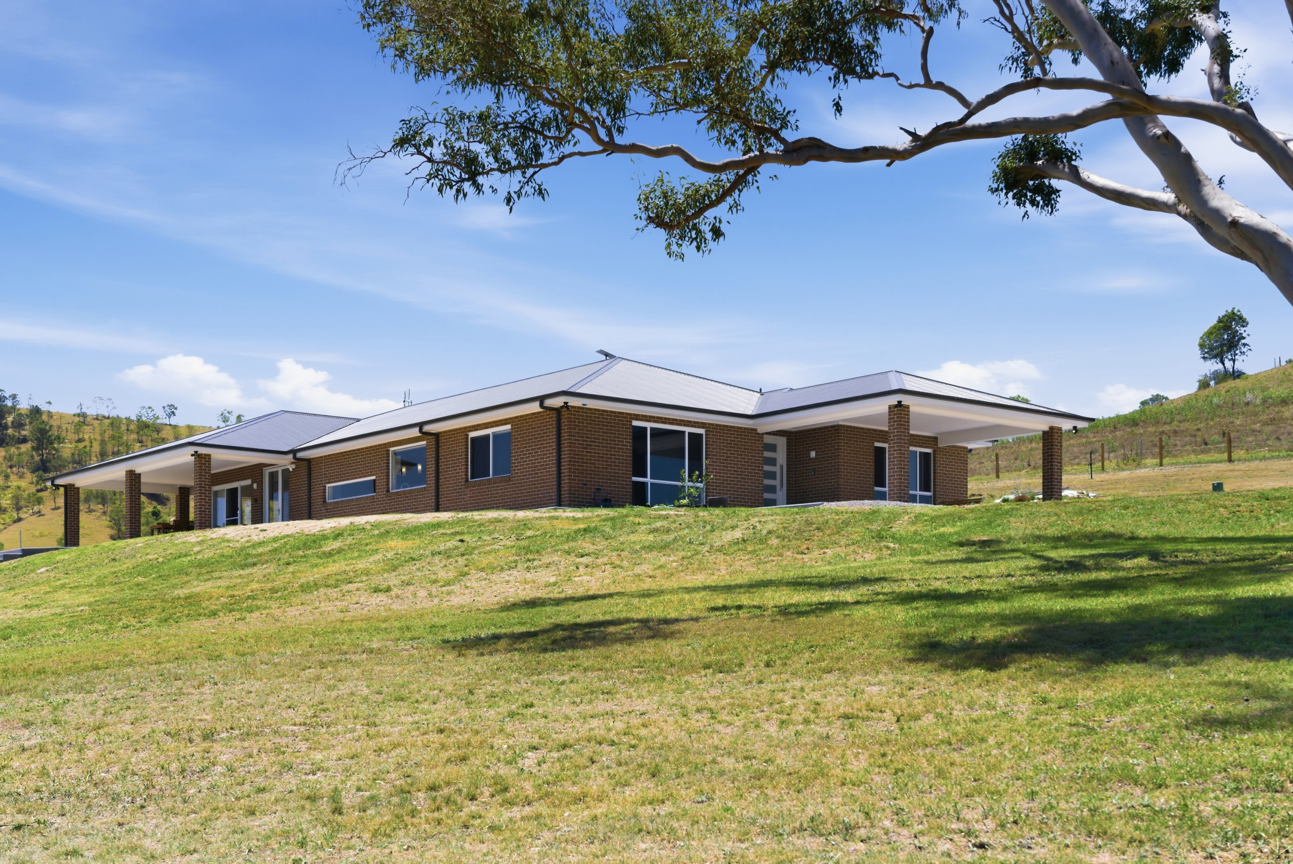 Florence Talbot House luxury farm stay exterior surrounded by green hills and eucalyptus trees, Strathbrook Farm Dungog